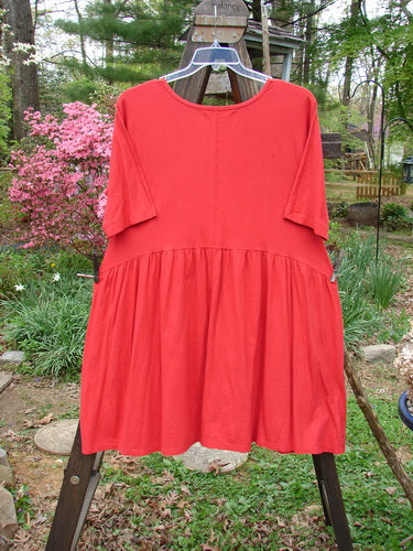 Barclay Studio Boxcar Dress, Size 1, in Real Red. Mid Weight Organic Cotton. Rounded neckline, curved waist seam, gathered lower flounce, and side pockets. Unpainted for easy layering. Bust 44, Waist 46, Hips 56, Sweep 80, Length 36.
