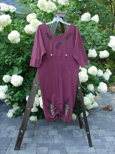 1993 Deep Neck Button Dress Woodberry Roman Strings OSFA: A purple dress on a wooden stand, featuring a deep and wide neckline, lower tapering shape, and three vertical bottom interior draw cords.