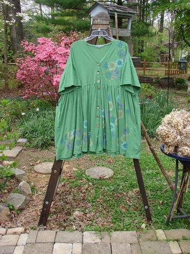 Image alt text: Barclay Tree Dress, a green dress with floral blossom theme, V neckline, gathered full lower, and slight empire waistline.
