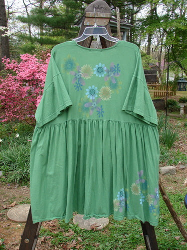 Barclay Tree Top Cardigan Dress, a green dress with floral blossom design, made from light organic cotton. Baby doll style with vintage buttons, V neckline, gathered full lower, and slight empire waistline. Size 3, perfect condition.