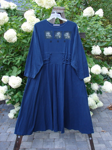 1997 Caryatid Dress Quad Art Window Pane Size 2: A vintage blue dress with patch accents and adjustable laces in the front and back. Made from organic cotton, it features a sweeping A-line lower and drop shoulders. Bust 52-60, waist 52-60, hips 62-70. Length 56 inches.