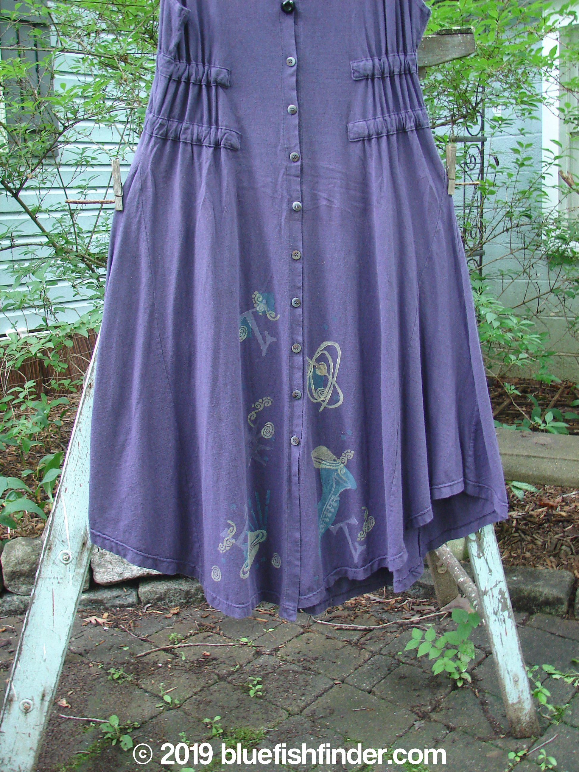 1994 Spin Jumper Mixed Purple Nuit Size 2: A purple dress with a design on it, featuring an empire waist, V-shaped neckline, and sweeping hemline.
