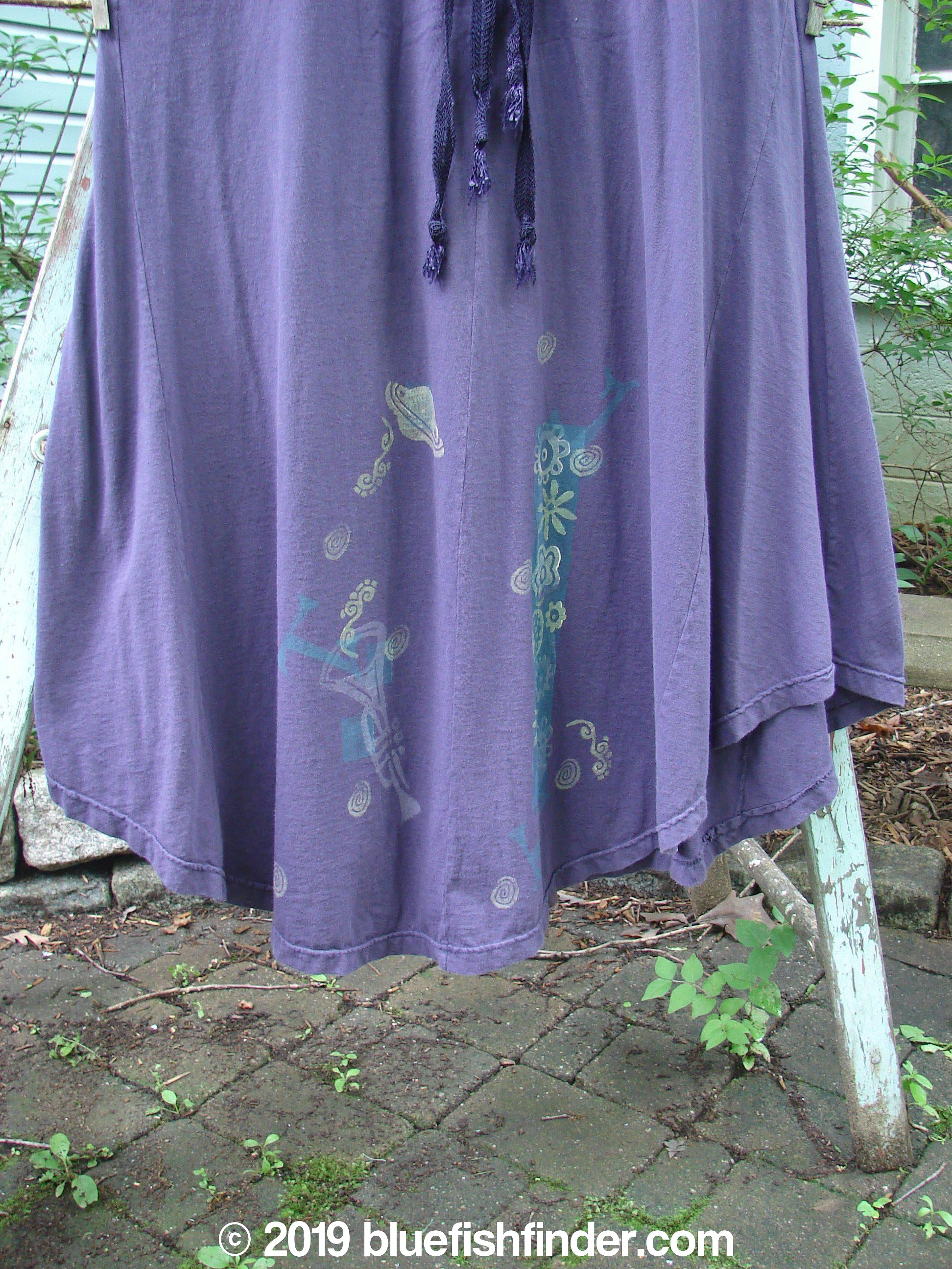 1994 Spin Jumper Mixed Purple Nuit Size 2: A purple dress on a white stand with a design on it, featuring an empire waist, V-shaped neckline, and sweeping hemline.