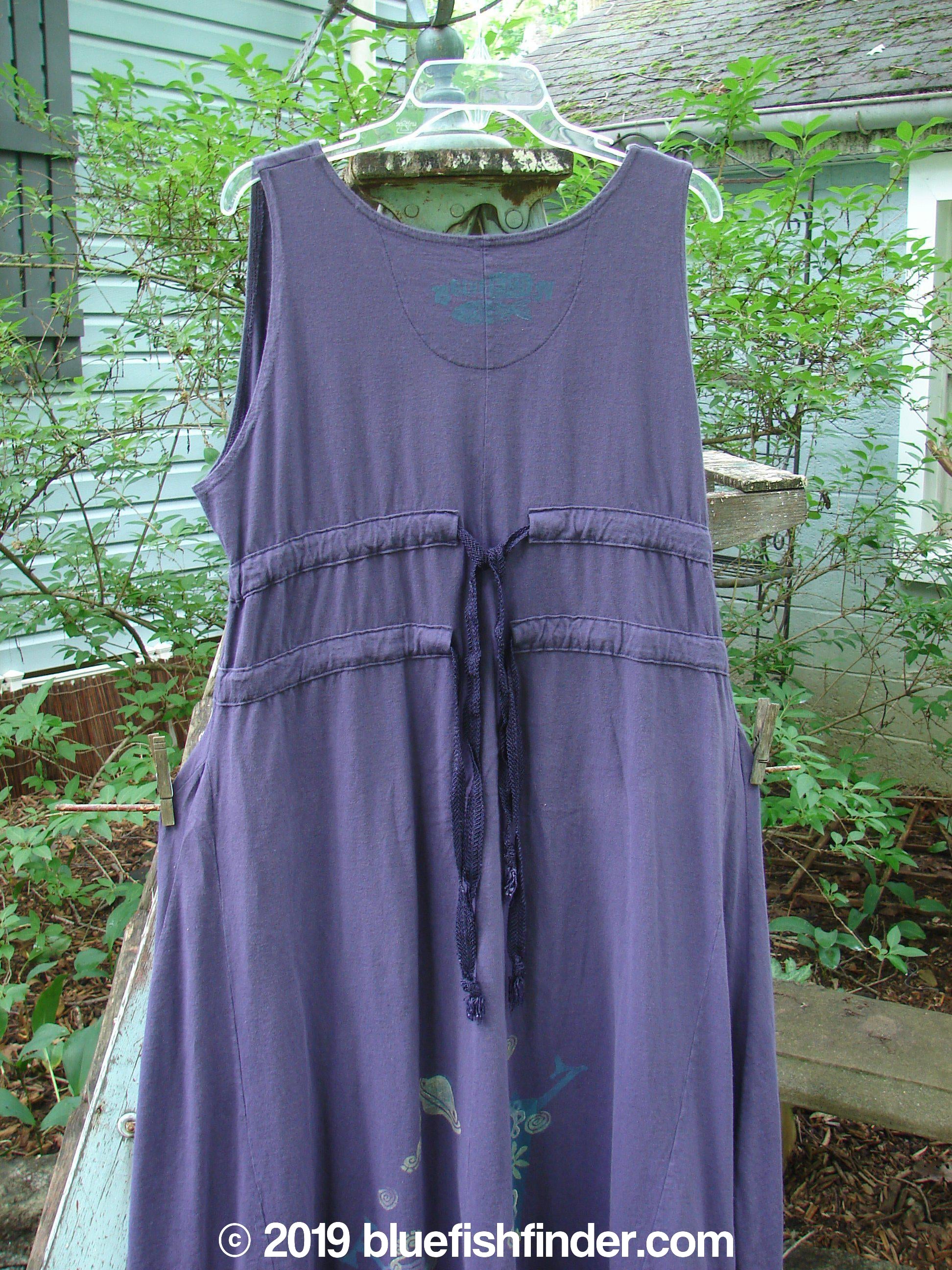 1994 Spin Jumper Mixed Purple Nuit Size 2: A medium weight cotton dress with an empire waist, V-shaped neckline, and sweeping hemline. Features a nature-themed paint design with leaves and vines.