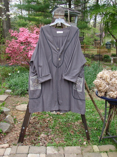 A grey Tiddly Winks Jacket with butterfly accents, ceramic buttons, and pleated back. Made from organic cotton. Size 2. 1998 Summer Collection.