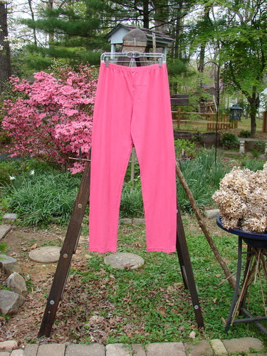 Barclay NWT Cotton Lycra Bally Layering Pant Legging Unpainted Flamingo Size 2: Pink pants on a rack, close-up of a wheel, and a plant.
