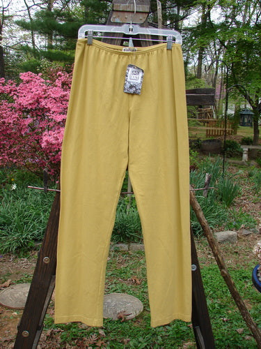 Barclay NWT Cotton Lycra Bally Layering Legging Unpainted Oil Yellow Size 2: A pair of yellow pants on a clothes rack, perfect for layering.