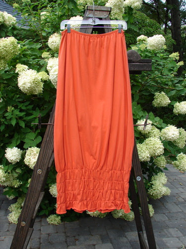 2000 Rings of Saturn Skirt on wooden ladder. Orange cloth close-up. Light, organic cotton. Elastic waist, smocking. Size 2. 43" length.