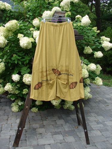 2000 Cotton Hemp Shade Skirt Bio Cell Gold Size 2: A pair of shorts on a rack, a yellow dress with butterflies on it, and a yellow cloth with butterflies on it.