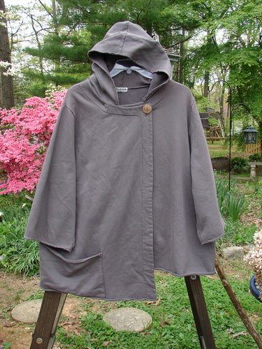 Barclay Interlock Single Button Hooded Jacket Unpainted Dust Plum Size 2: A cozy grey hooded jacket with a single button closure on a wooden easel.
