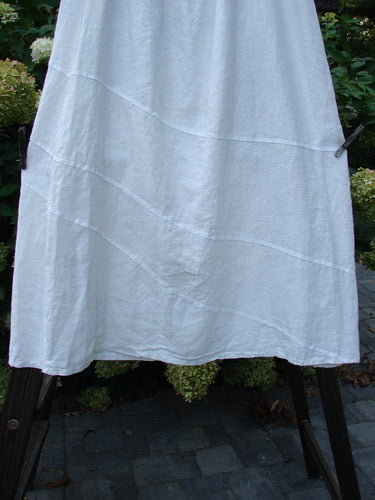 A white Barclay Linen Diagonal Skirt, size 2, on a rack. Exquisite woven hemp and linen fabric. Boxier length with diagonal stitchery.