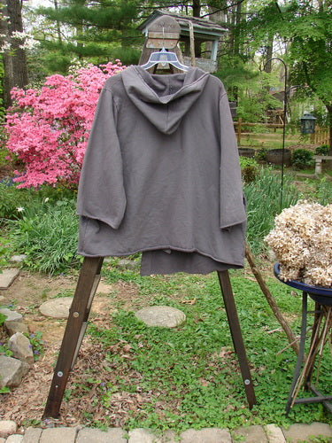 Barclay Interlock Single Button Hooded Jacket Unpainted Dust Plum Size 2: A grey jacket on a rack with a cozy hood and a single cross over front button closure.