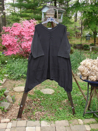 Barclay Vector Tunic Dress Unpainted Black Size 2: A black tunic dress with a wider V-shaped neckline, dip side varying hemline, and sectional horizontal stitchery. Features exterior drop front pockets and lower sleeve lettuce edges.