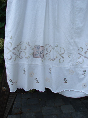 Barclay Linen Duet Skirt: White dress with tiny floral design, elastic waist, widening bell shape, sectional panels, V-shaped insert, varying hemline, and cotton lower flutter. Perfect condition. Size 2. Length: 40".