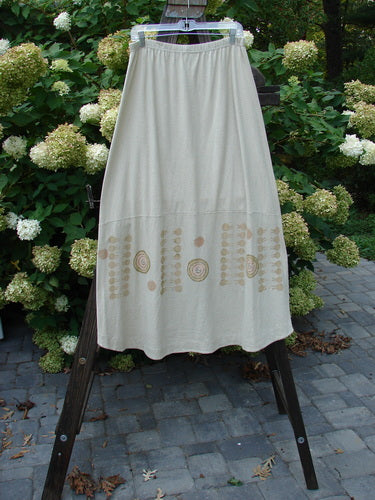 2000 Cotton Hemp Shade Skirt Bio Atom Dove Size 2: A white dress on a wooden easel, showcasing a lovely hemp cotton blend fabric. The skirt features a full elastic waistband, an upward scoop, and a varying hemline when tied with the extra long rippie. With 3 vertical loops for adjustable styling and sectional horizontal panels, this skirt embodies the classic resort biology theme. Waist: 30-52, Hips: 52, Hem Circumference: 70, Length: 37 inches.