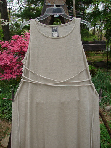 1998 Linen Knit Wrap Dress Unpainted Natural Size 1: A dress on a clothes line, featuring a flowing linen knit fabric, rounded rolled neckline, and a lower flair.