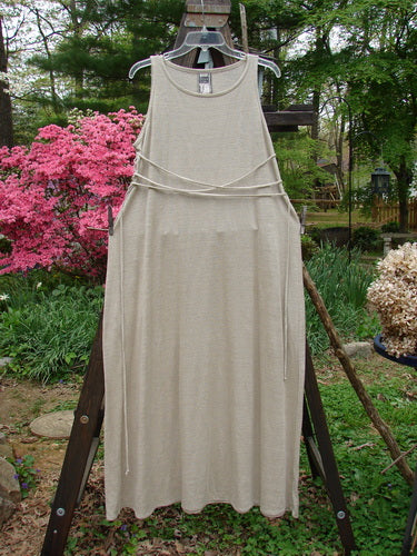 1998 Linen Knit Wrap Dress Unpainted Natural Size 1: A dress on a clothesline, with a flowing linen knit, rounded rolled neckline, and elegant drape.