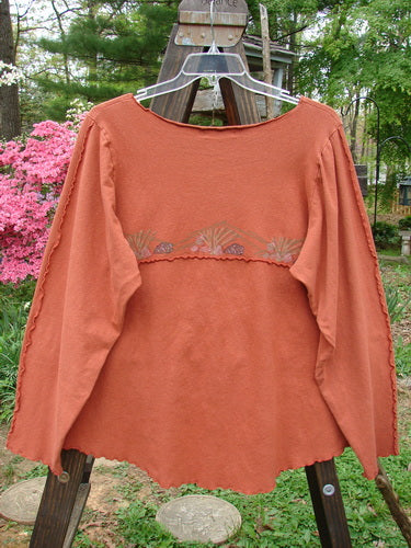 Barclay Cotton Lycra Curly Sectional Top Sea Shells Burnt Orange Size 2: A long sleeved shirt featuring a swinger, pink flowers, and a hand holding a coin.
