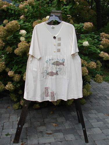 A white Barclay Tunnel Pocket Pull Over Dress with fish theme paint, made from organic cotton. Features include a three-button top, rear drawcord, and a generous front drop tunnel kangaroo pocket. Bust 58, Waist 60, Hips 64, Sweep 80, Length 38.
