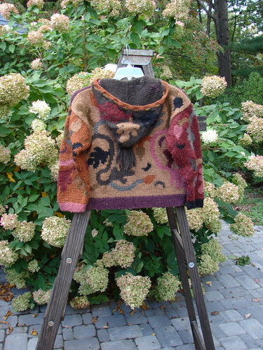 A Tara Handknit Child's Sweater in Size Large, designed by the Hot Knots Sisters, Andrea and Gayle Shackleton. This vintage beauty features colorful patterns, a cozy ribbed neckline, and a draw cord hoodie accent with a thick tassel. Complete with oversized metal buttons and a kangaroo cargo pocket, this luxurious piece promises to be a winter favorite. Bust: 40, Waist: 40, Hips: 40, Length: 20 inches.