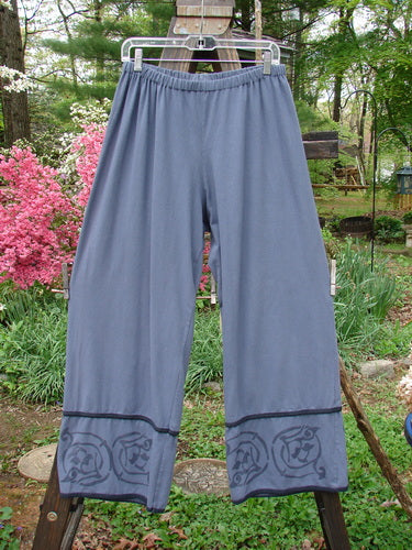 A pair of Barclay Cotton Lycra Tic Tac Toe Pant Wind Bottom Blue Dusk Size 2 hanging on a clothesline.