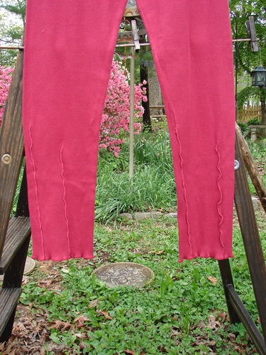 Barclay Cotton Lycra Layering Pinch Rib Pant Legging Unpainted Cranberry Size 2: A pair of pants on a wooden rack, featuring a soft textured rib feel and slightly fluttered lowers. Perfect condition, made from cotton lycra and organic cotton rib.