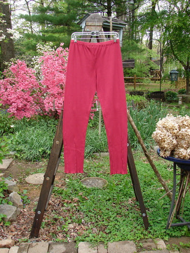 Barclay Cotton Lycra Layering Pinch Rib Pant Legging Unpainted Cranberry Size 2: A pair of pants on a rack in a garden, featuring a soft forgiving textured rib feel and slightly fluttered lowers.
