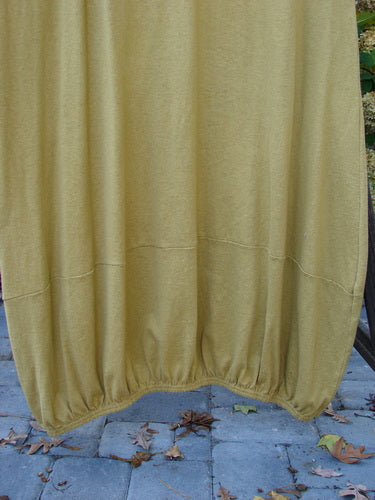 2000 Cotton Hemp Libby Jumper Unpainted Gold Size 2: A yellow cloth jumper with a downward scooped waistline, 2 side pockets, and a bubbled shape.