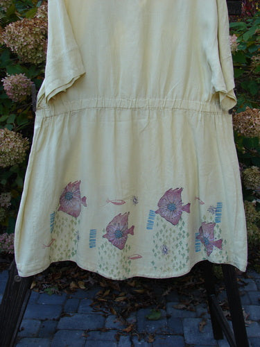 Barclay Linen Flower Button Gather Back Tunic Dress Undersea Plantain Size 2: A white dress with fish design, pearly button flower front, A-line shape, rounded hemline, and slightly longer short sleeves. Elastic drop waistline in the rear. Made from medium weight linen.