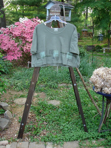 Image alt text: City Side Crop Tee Top with Navigation Border in Park, Size 2 - A shirt on a rack with a close-up of a sheep and a metal bar.