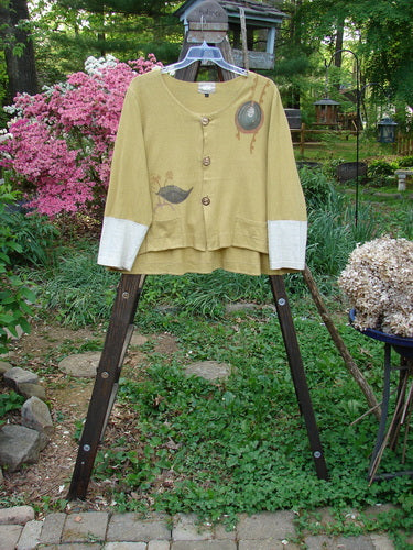 Image alt text: "2000 Cotton Hemp Philois Jacket, yellow sweater on a rack, close-up of a sheep, jacket on a rack, person standing next to a bush of pink flowers, close-up of a metal pole, yellow sweater with a bird design on it, wooden ladder with a cloth on it"