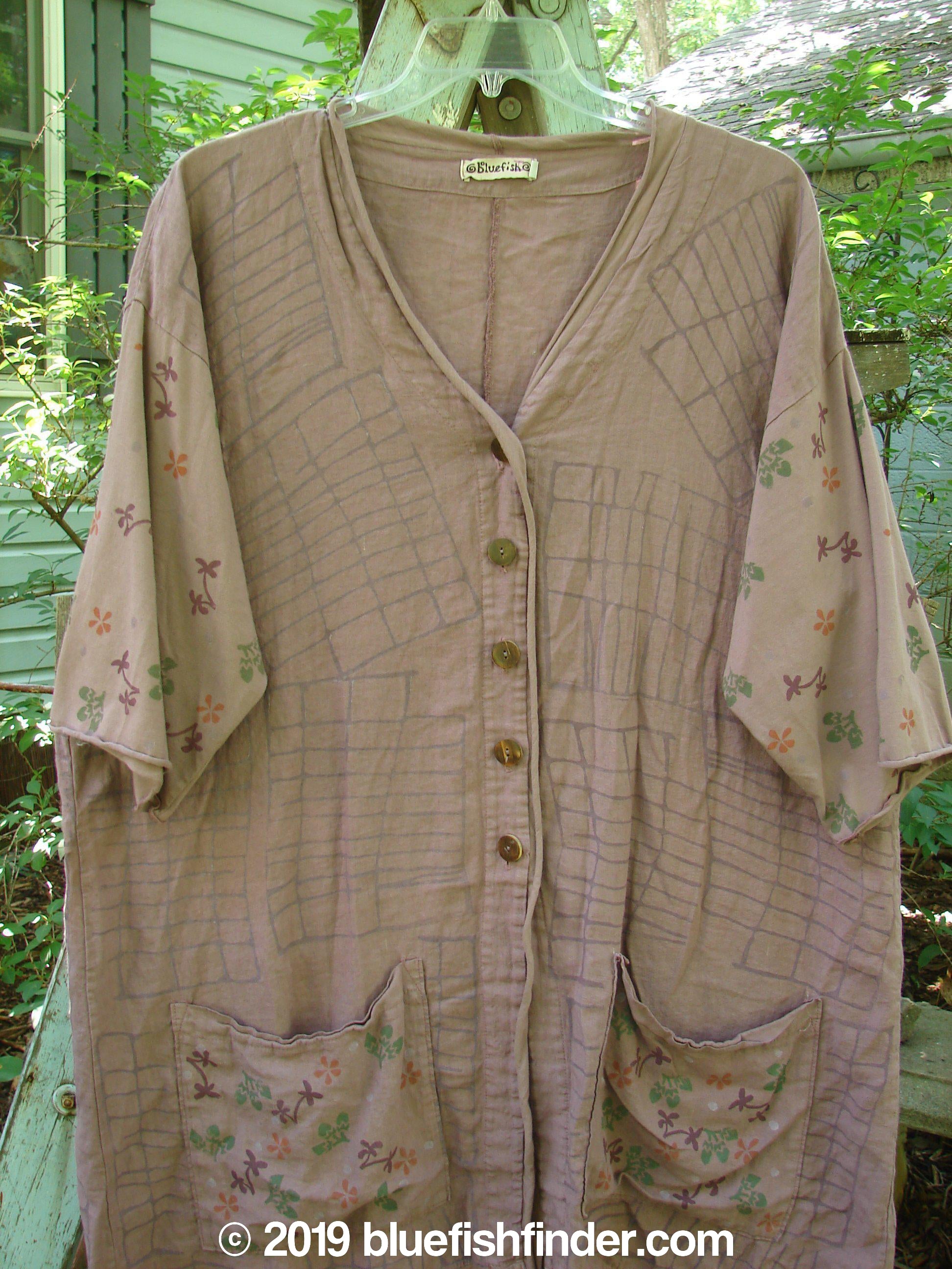 Barclay Linen Cotton Sleeve Pocket Cardigan in Rich Mauve, Size 0. A brown shirt with a map design on it, featuring a pocket with flowers and leaves.