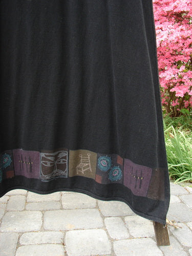 Barclay Hemp Cotton Curved A Line Dress, Size 2: Black fabric with a design featuring Kitty Kitty and High Back Chair themes along the hem. A wide A-line shape with longer cozy sleeves and a downward curved empire waist seam. Bust 52, Waist 56, Hips 58, Sweep 90, Length 57 inches.