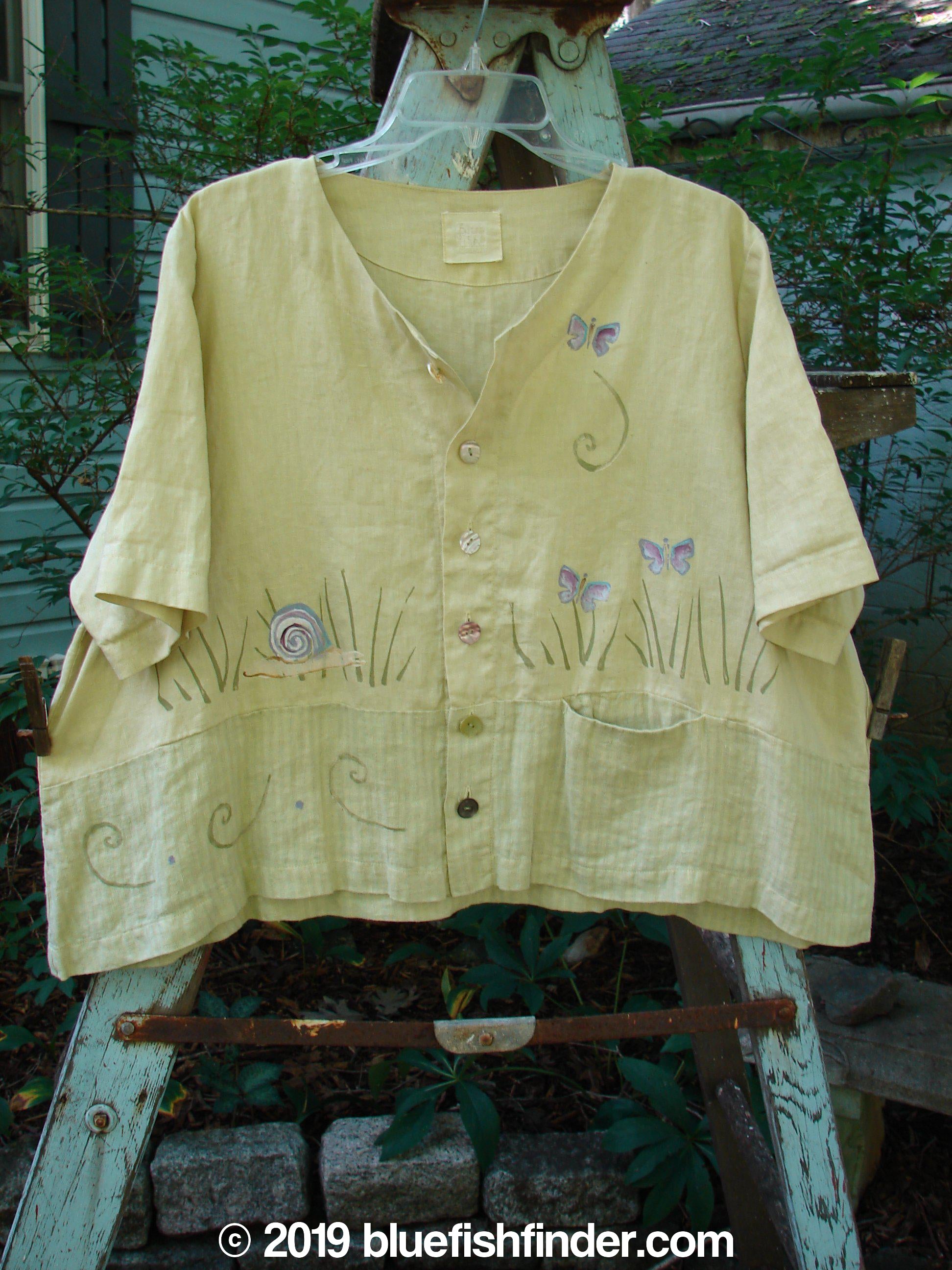 1999 Cabana Top with butterflies and snails painted on it, made from light textured linen. Features include a crop shape, shell buttons, varying hemline, and a contrasting fabric lower panel. Size 2.