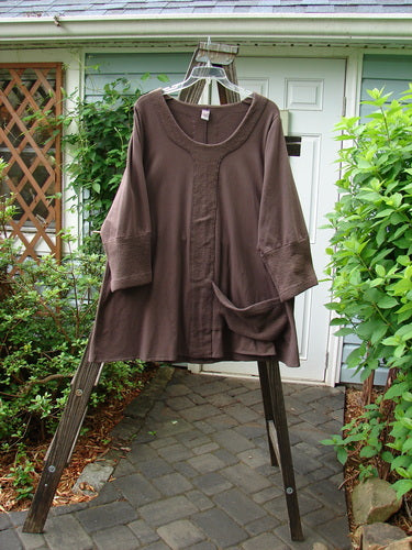 Image alt text: Barclay Cotton Lycra Celtic Moss Single Pocket Tunic Top in Mocha, size 1, on a clothes rack with a close-up of a plant.