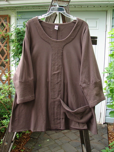 A medium weight cotton lycra tunic top in mocha with Celtic Moss accents. Features include a soft single side front pocket, A-line shape, and Celtic Moss vertical center panels. Size 1.