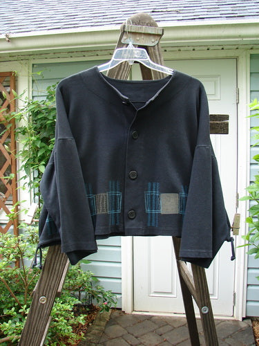 1999 Interlock Side Tie Jacket Fall Grid Black Size 2: A black sweater with wide belled sleeves and a unique rubber-like button front.