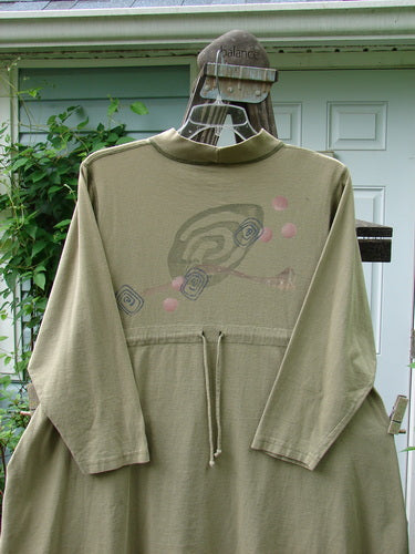 A long sleeved shirt on a swinger, part of the 1996 Ramble Dress Follow Path Bottlecap Size 1 collection. Made from organic cotton, it features a ribbed mock T neck, oversized front pocket, and exterior stitching. Perfect condition.