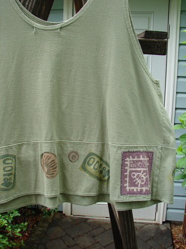 1995 Klee Top Pine Forest Marsh Size 2: A green apron with various designs, a stamped ceramic button, and a playful, swingy A-line crop shape.