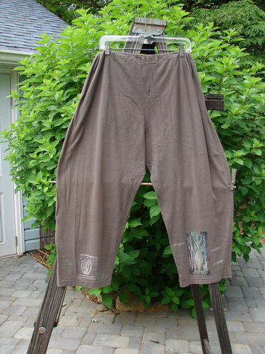 1994 Wanderer's Pant Spirit Woman Humus Size 1: A pair of pants on a clothesline, made from medium-weight cotton jersey. Features include a drawstring waistline, front pockets, and a crop length. Perfect for a distinctive, individualized look.