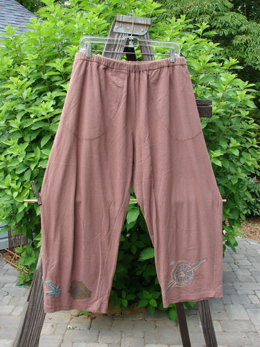 A pair of vintage Crossroad pants from the 1993 Resort Collection in Dusty Rose. Mid-weight cotton with a professionally replaced elastic waistband. Features highly detailed vintage travel theme paint, side entry front pockets, and a sweet summertime crop with a slightly tapered inseam. Perfect for fishers who like to travel or relax at home. Waist Relaxed 28, Waist Extended 38, Hips 60, Length 38, Inseam 25.