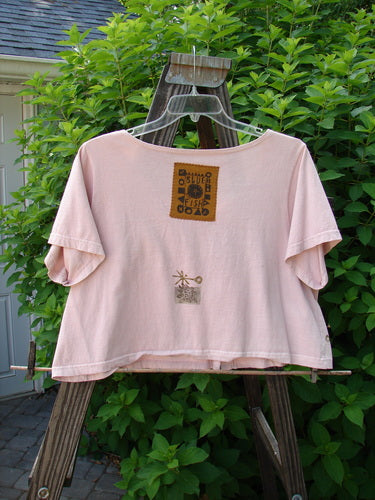 1993 Travel Top Oval Gardens Dried Rose Size 1: Pink shirt on a swinger with lovely crop shape. Signature Blue Fish patch and button accents. Perfect layering piece for a tiered look. Bust 50, waist 50, length 19 inches.