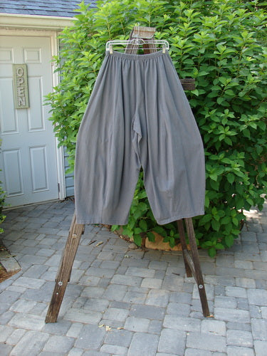Image alt text: "1997 Nuts and Bolts Pant on wooden rack, featuring nifty painted pockets, elastic waistline, and deep side pockets. Size 1, waist 28-38, hips 80, inseam 24, length 38."