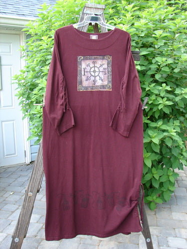 1999 Starlight Dress in Deep Burgundy, Size 2. Made from Mid Weight Organic Cotton. Features a Double Layered Neckline, Sleeve Lacings, and a Straight, Longer Shape. Celtic Compass Theme Paint. Vertical Drawcord Hem Accents. Length: 54 Inches.