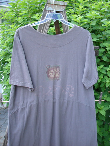 1999 Windmill Dress Butterfly Raven Size 2: A grey shirt with a logo on it, featuring a sweeping A-lined shape, squared and double paneled neckline, downward yoked waist, and flared hemline. Includes signature Blue Fish patch and darling butterfly and nature theme paint.