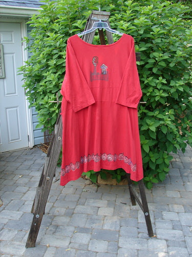 A Barclay Lace Up Panel Duster in Ruby, featuring a deep V-shaped neckline, downward yoked rear drop panel, and leaf theme border paint. Three quarter length sleeves and a slightly varying hemline complete the design. Size 2.