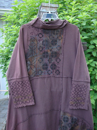 Image alt text: "Barclay Fold Over Collar Puzzle Tunic Dress, a long purple shirt with a pattern on it, featuring sectional panels, stitchery, varying hemline, curley edges, and an oversized drop front pocket. Size 1."

Note: The alt text has been shortened to fit within the 120-character limit while still providing a clear and concise description of the image.