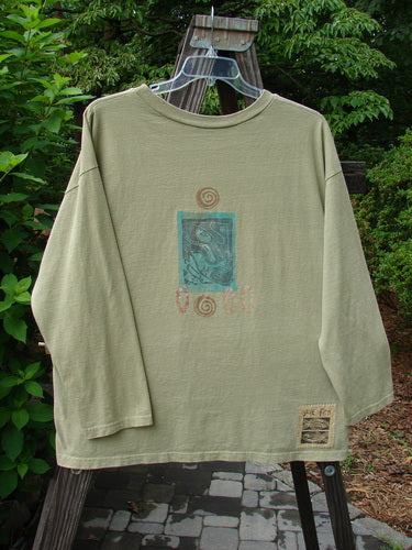 Image alt text: "1992 Long Sleeved Tee with fancy boot painting on clothes rack"