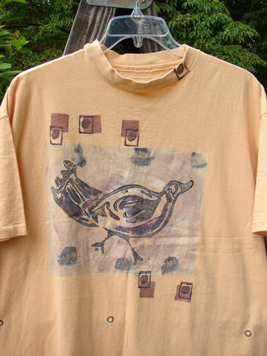 1991 Short Sleeved Tee featuring a bird design on a marigold t-shirt. Boxy shape, shorter sleeves, ribbed neckline, and vintage Blue Fish patch. Bust 50, waist 50, length 30 inches.