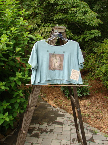 1994 Song Top Multi Letter "K" Ice Size 1: A t-shirt on a swinger with a wide boxy shape, shallow neckline, and front painted pocket. Vintage Blue Fish Clothing.